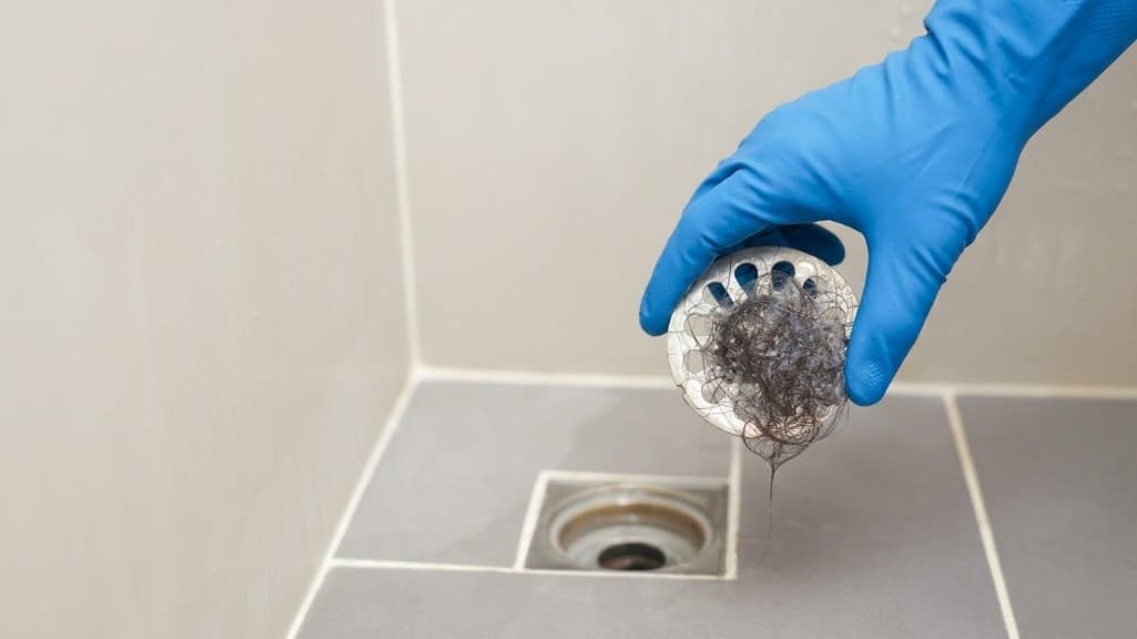 Cabellos tapando rejilla de ducha